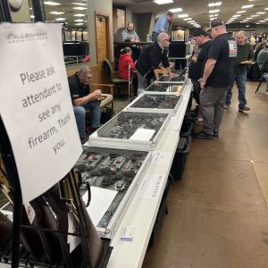Attendants looking at guns in a case